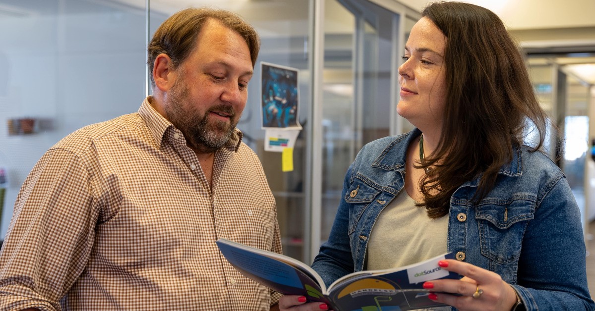 Zwei Personen schauen gemeinsam in ein Buch.